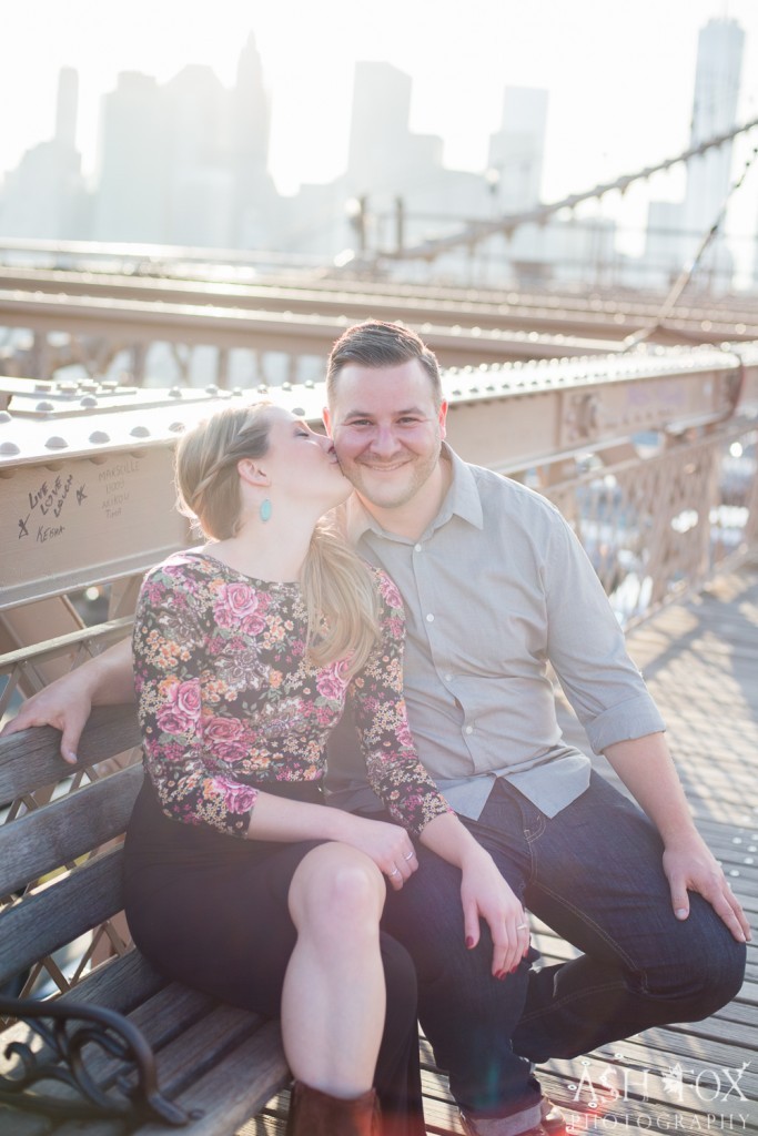 man and woman on brooklyn bridge bench kissing